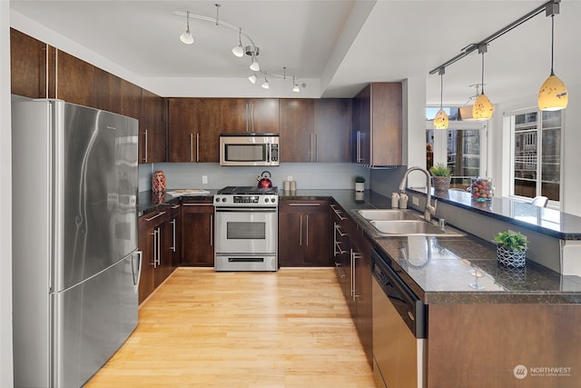 kitchen featuring dark brown cabinetry, light hardwood / wood-style floors, sink, appliances with stainless steel finishes, and pendant lighting