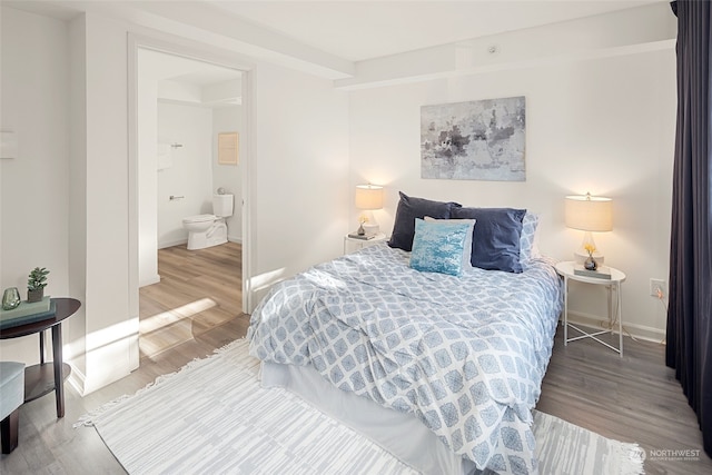 bedroom with hardwood / wood-style flooring and ensuite bathroom