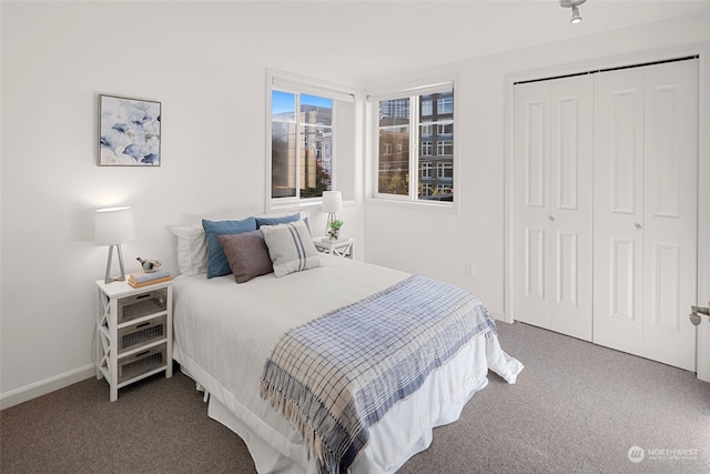 bedroom with a closet and dark carpet