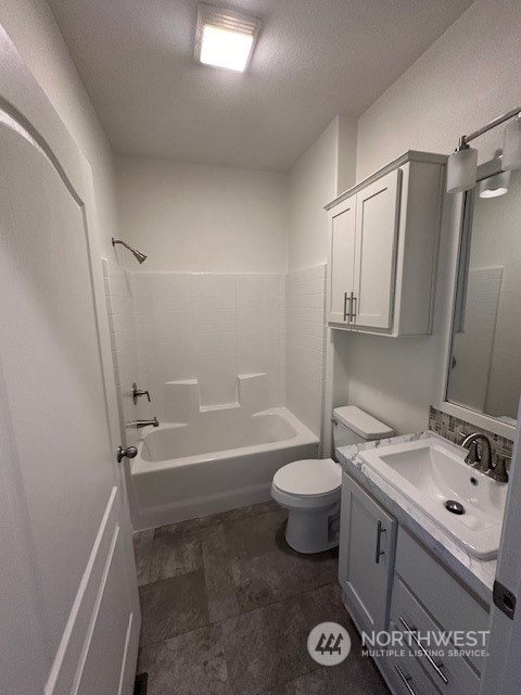 full bathroom featuring vanity, a textured ceiling, toilet, and shower / bathtub combination