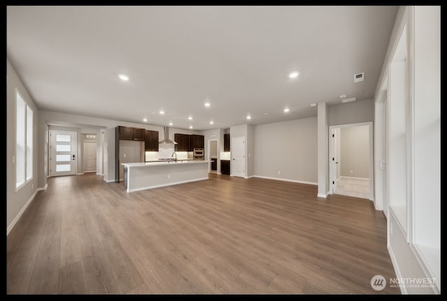 unfurnished living room with hardwood / wood-style floors and sink