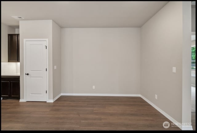 unfurnished room with dark wood-type flooring