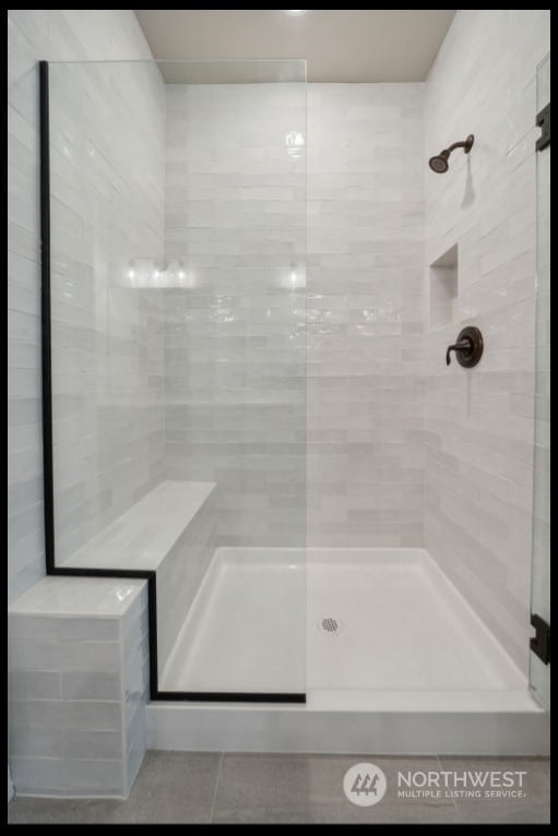 bathroom with tiled shower and tile patterned floors