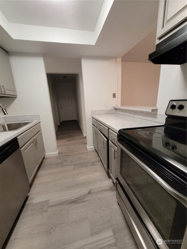 kitchen with gray cabinets, sink, light wood-type flooring, and stainless steel appliances