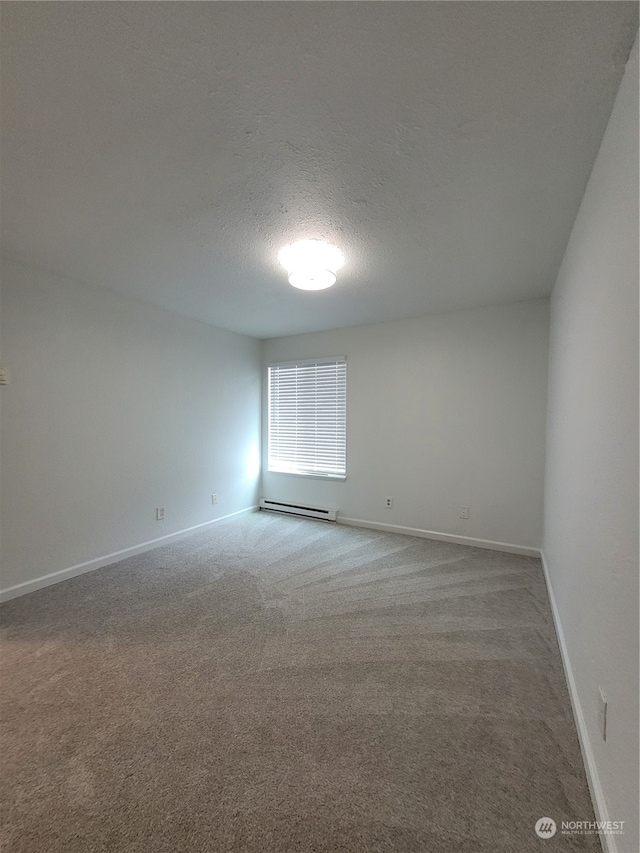 carpeted spare room with a textured ceiling and baseboard heating