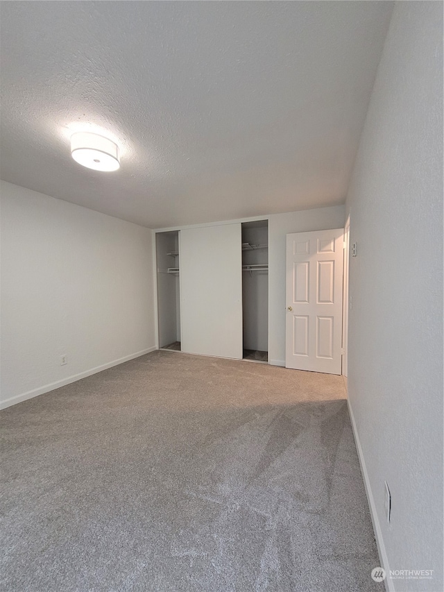 unfurnished bedroom featuring a closet, carpet floors, and a textured ceiling