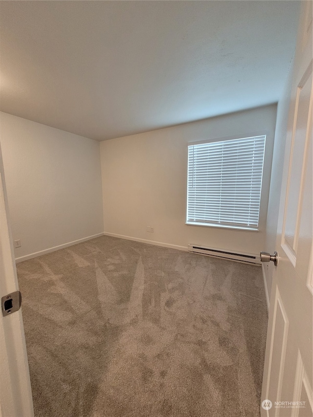 carpeted empty room with a baseboard radiator