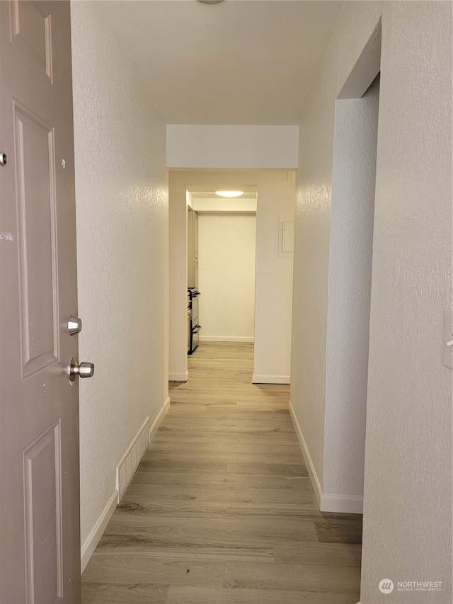 corridor with light hardwood / wood-style flooring