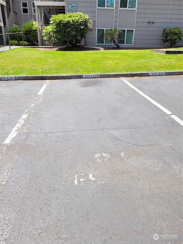 view of parking / parking lot with a lawn