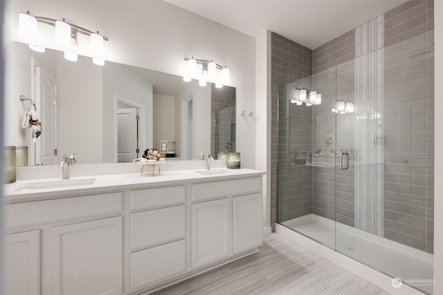 bathroom with hardwood / wood-style floors, vanity, and walk in shower