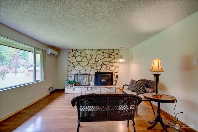 sitting room with hardwood / wood-style flooring, a textured ceiling, and a wood stove