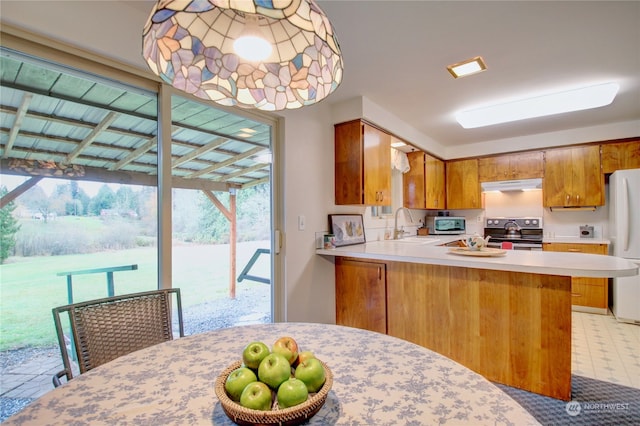 kitchen with stainless steel electric range, kitchen peninsula, sink, and white refrigerator