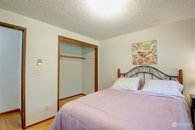 bedroom featuring a closet, a textured ceiling, and light hardwood / wood-style floors