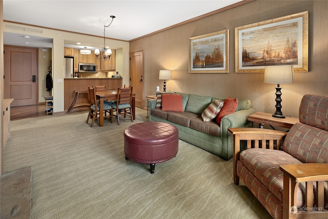 carpeted living room with a chandelier and crown molding