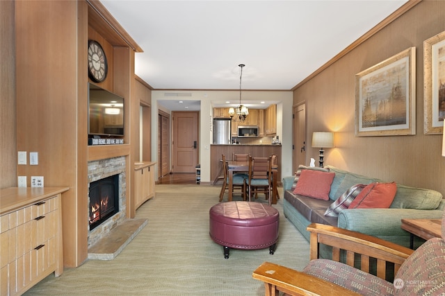 carpeted living room with an inviting chandelier, ornamental molding, and a fireplace