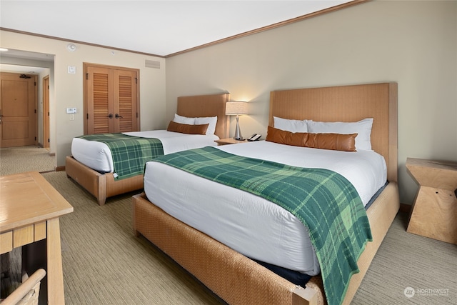 carpeted bedroom featuring a closet and ornamental molding