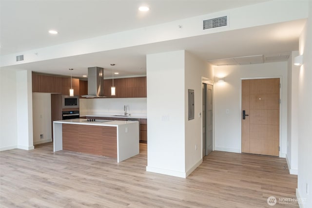 kitchen with stainless steel microwave, visible vents, island range hood, and modern cabinets