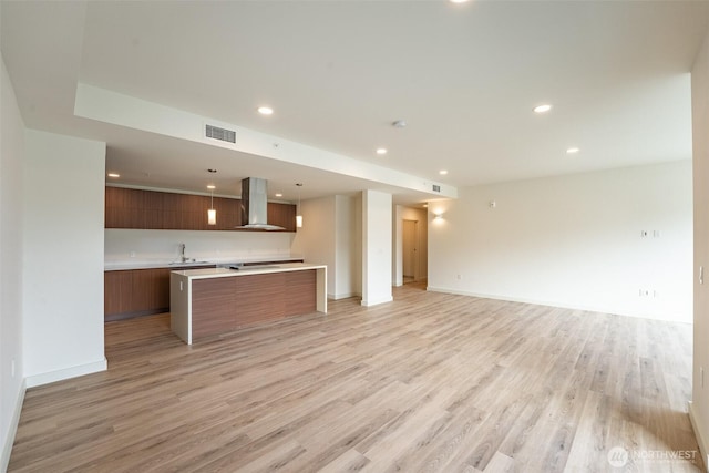 kitchen with visible vents, modern cabinets, open floor plan, light countertops, and exhaust hood