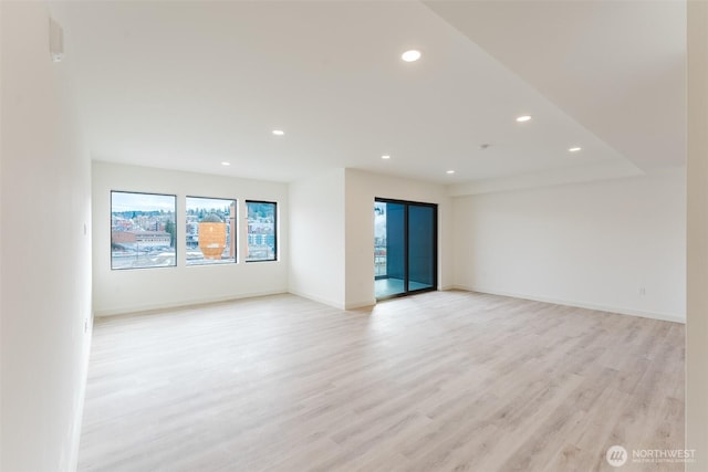 spare room featuring light wood-style flooring, baseboards, and recessed lighting