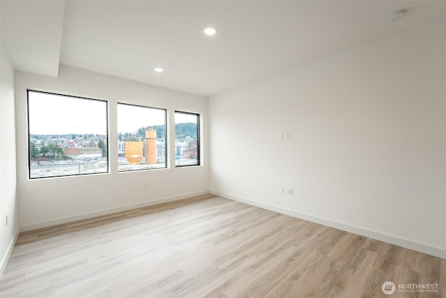 spare room with recessed lighting, light wood-style flooring, and baseboards