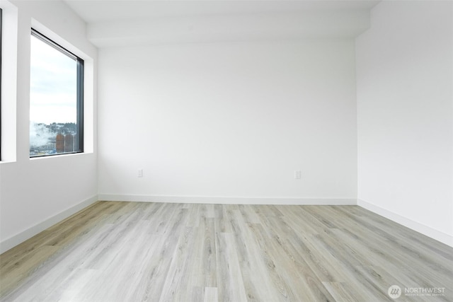 unfurnished room with light wood-style flooring and baseboards