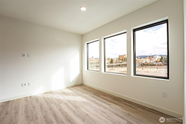 unfurnished room featuring recessed lighting, baseboards, and wood finished floors