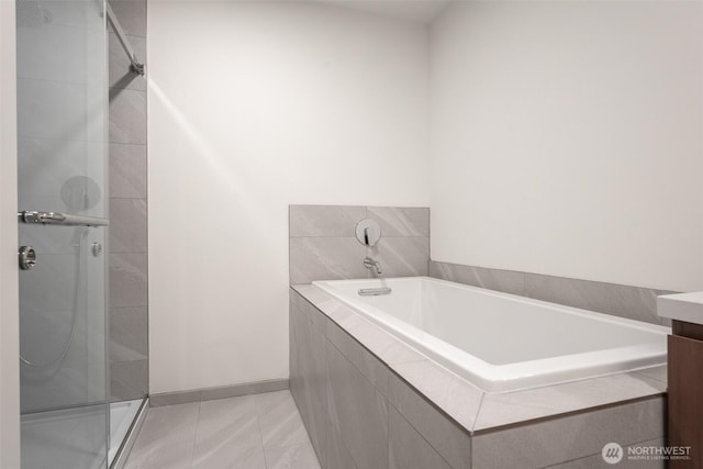 full bath featuring tile patterned flooring, vanity, baseboards, a shower stall, and a bath