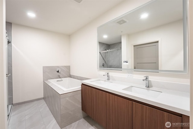 bathroom with double vanity, a sink, a shower stall, and a bath