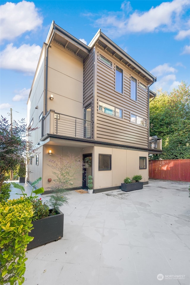 rear view of house with a patio and a balcony