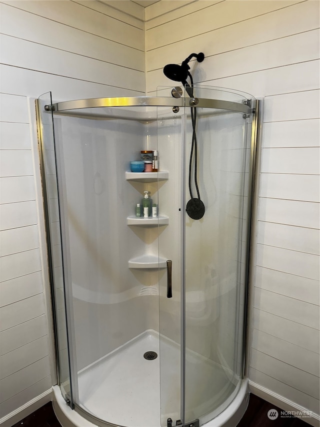 bathroom with walk in shower and wooden walls