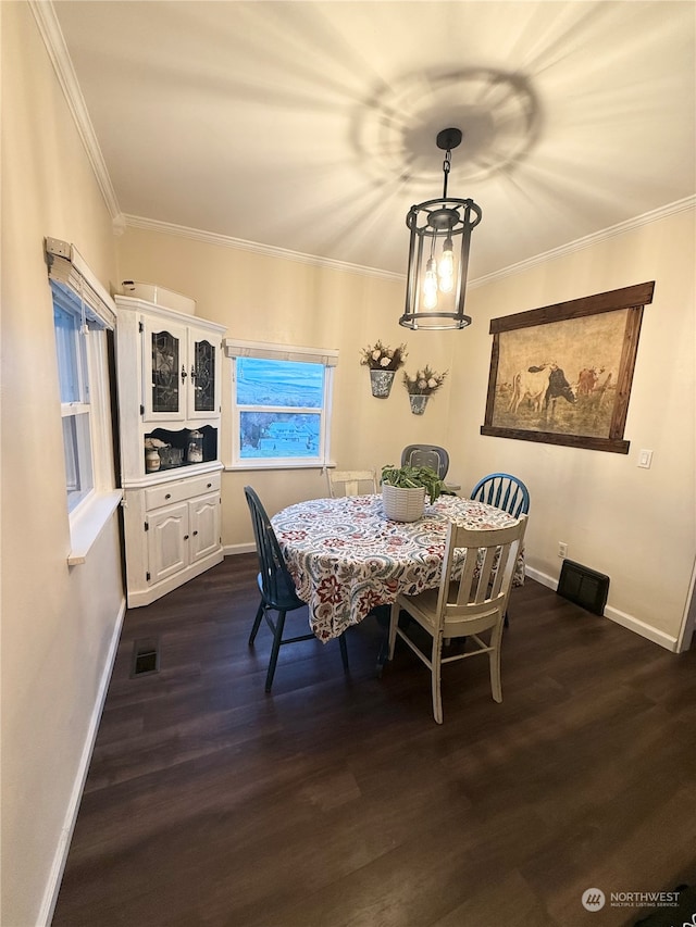 dining space featuring crown molding, an inviting chandelier, and dark hardwood / wood-style flooring