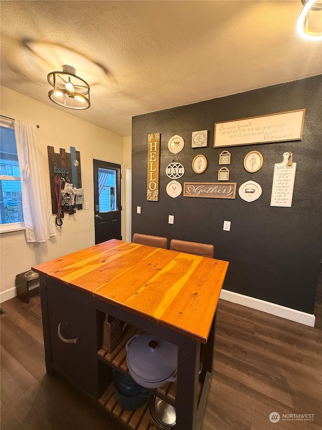 dining area with dark hardwood / wood-style floors and a textured ceiling