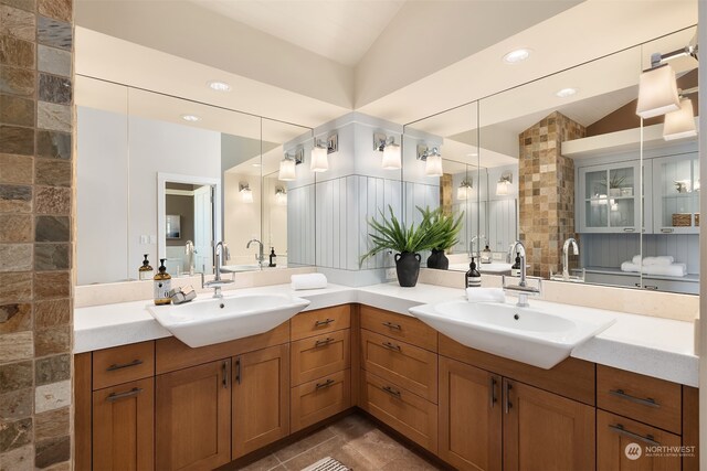 bathroom with vanity, vaulted ceiling, and tile patterned flooring