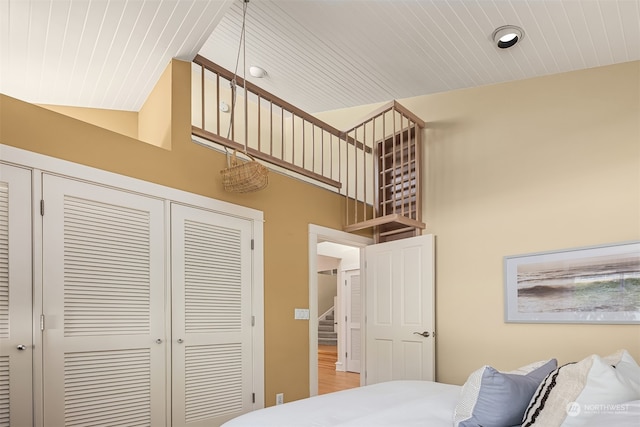 bedroom featuring a closet, high vaulted ceiling, and hardwood / wood-style flooring