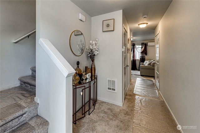 corridor with carpet floors, visible vents, baseboards, and stairs