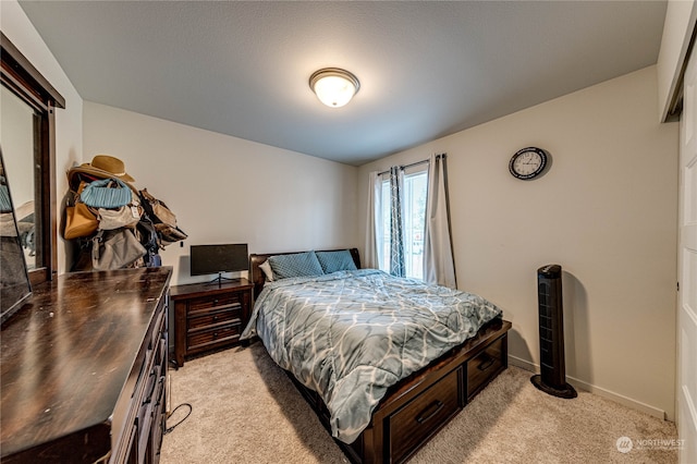 bedroom featuring light carpet and baseboards