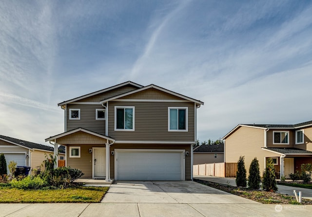 view of front of home with an attached garage, fence, and concrete driveway