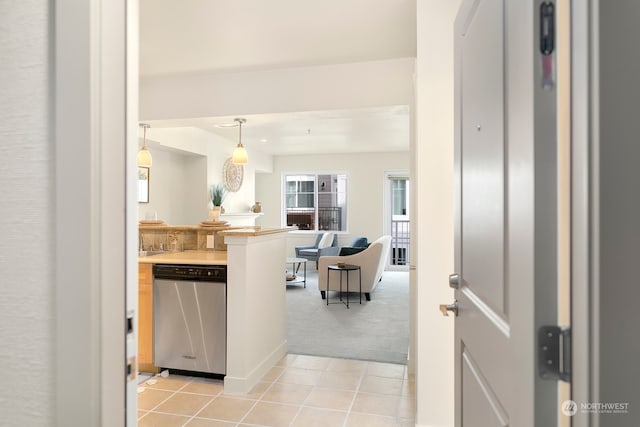 kitchen featuring dishwasher, light carpet, and pendant lighting