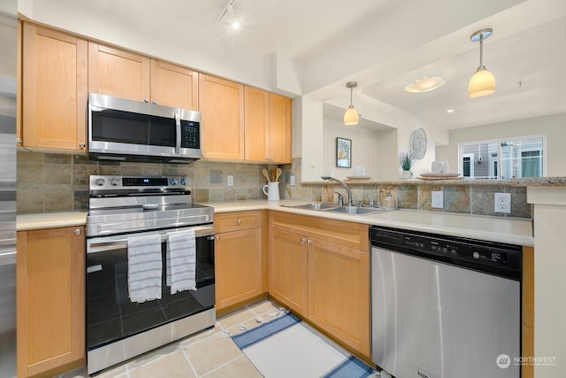 1545NW 57th St Unit 505, Seattle, WA 98107 - kitchen with stainless steel appliances, a sink, a peninsula, backsplash, and light countertops