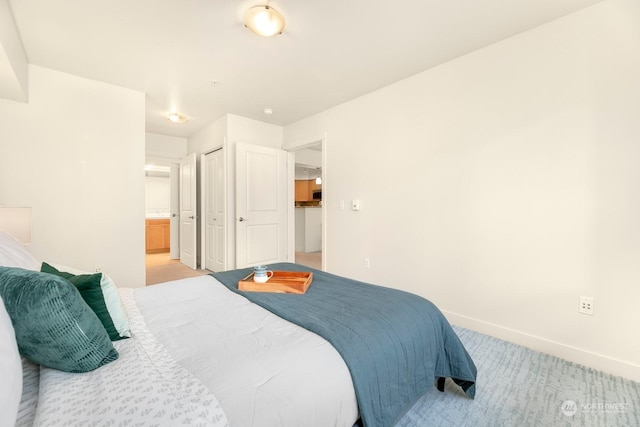 1545NW 57th St Unit 505, Seattle, WA 98107 - bedroom featuring light carpet, baseboards, ensuite bathroom, and a closet