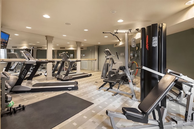 gym with ornate columns and light colored carpet