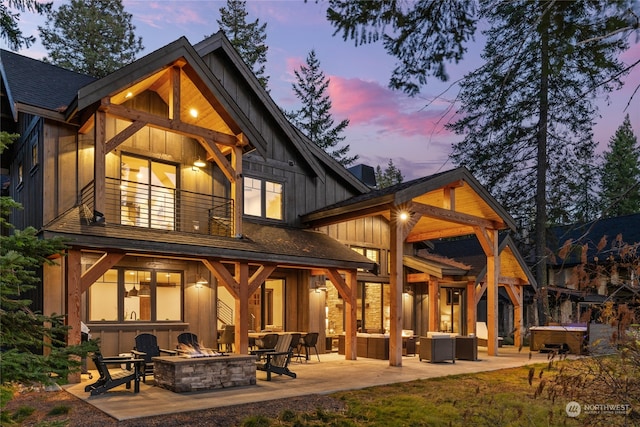 back house at dusk with central AC, a fire pit, and a patio