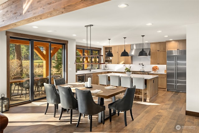 dining space with hardwood / wood-style floors, sink, and beverage cooler