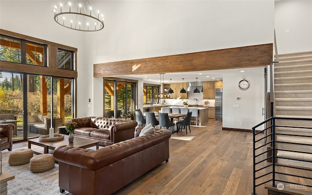 living room featuring hardwood / wood-style floors, a high ceiling, and an inviting chandelier