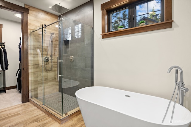 bathroom with hardwood / wood-style floors and shower with separate bathtub