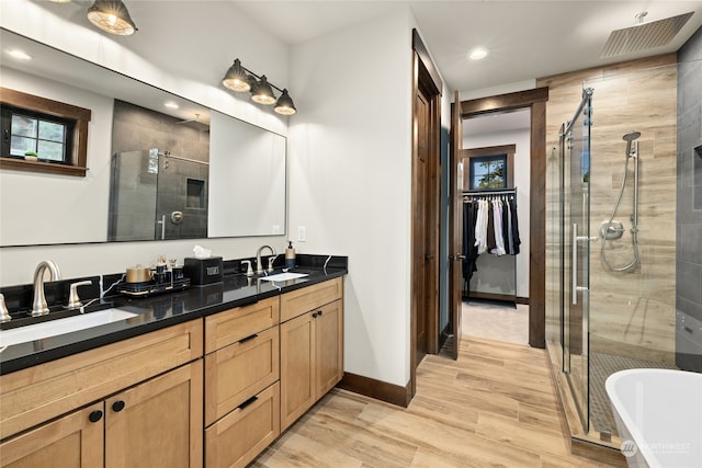 bathroom with hardwood / wood-style floors, vanity, and independent shower and bath