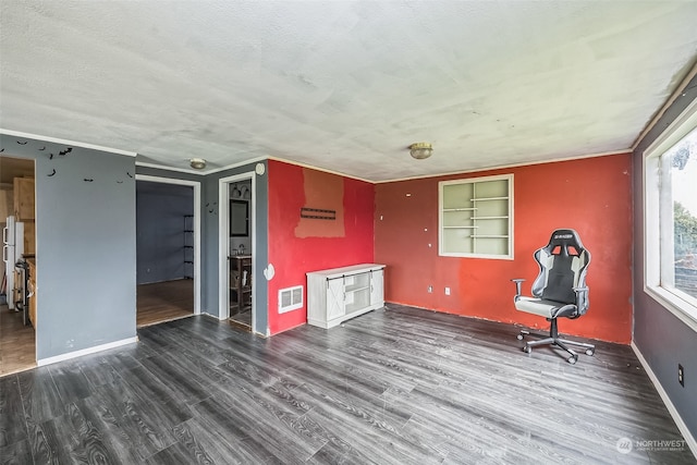 unfurnished room with a textured ceiling, dark hardwood / wood-style flooring, and built in features