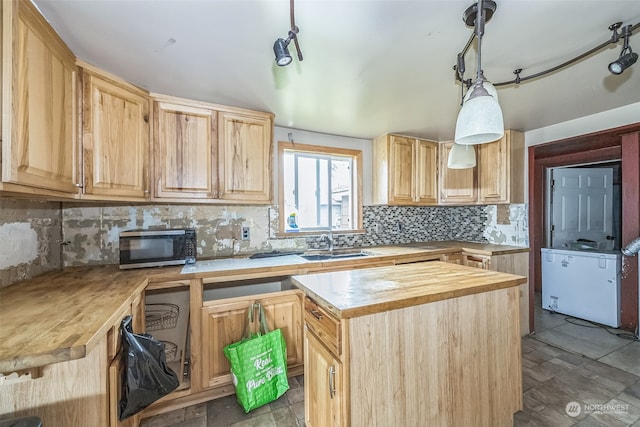 kitchen featuring sink, light brown cabinets, wooden counters, backsplash, and pendant lighting