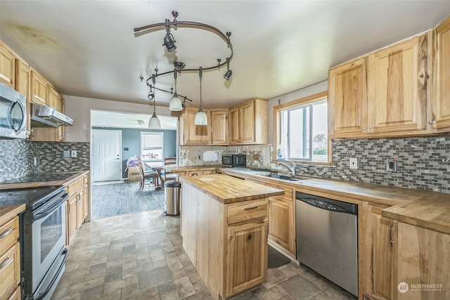 kitchen with butcher block counters, tasteful backsplash, pendant lighting, a kitchen island, and black appliances