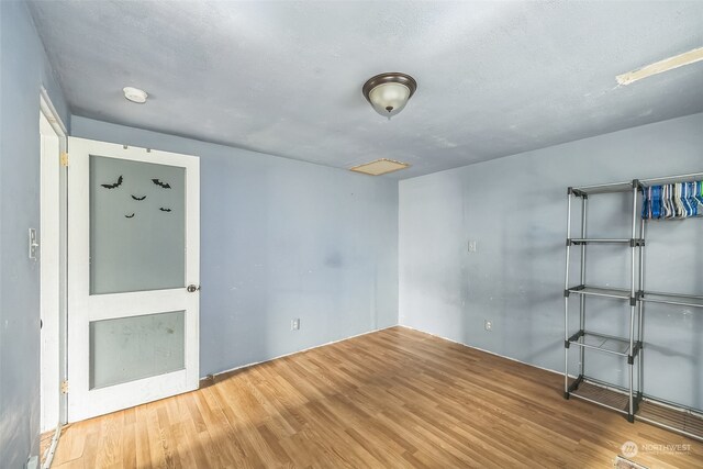 spare room with wood-type flooring and a textured ceiling